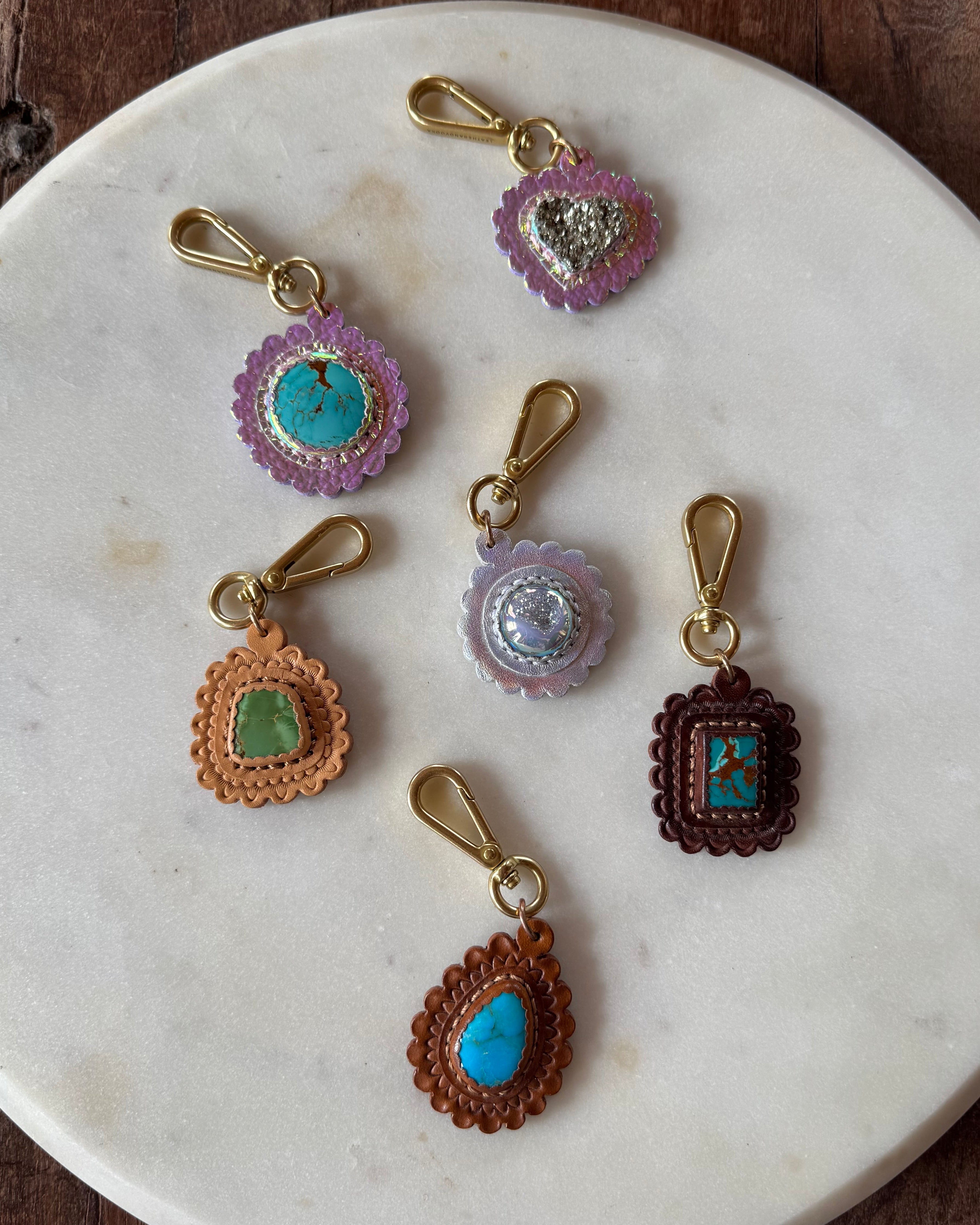 Set of decorative key chains on a marble plate with a wooden background