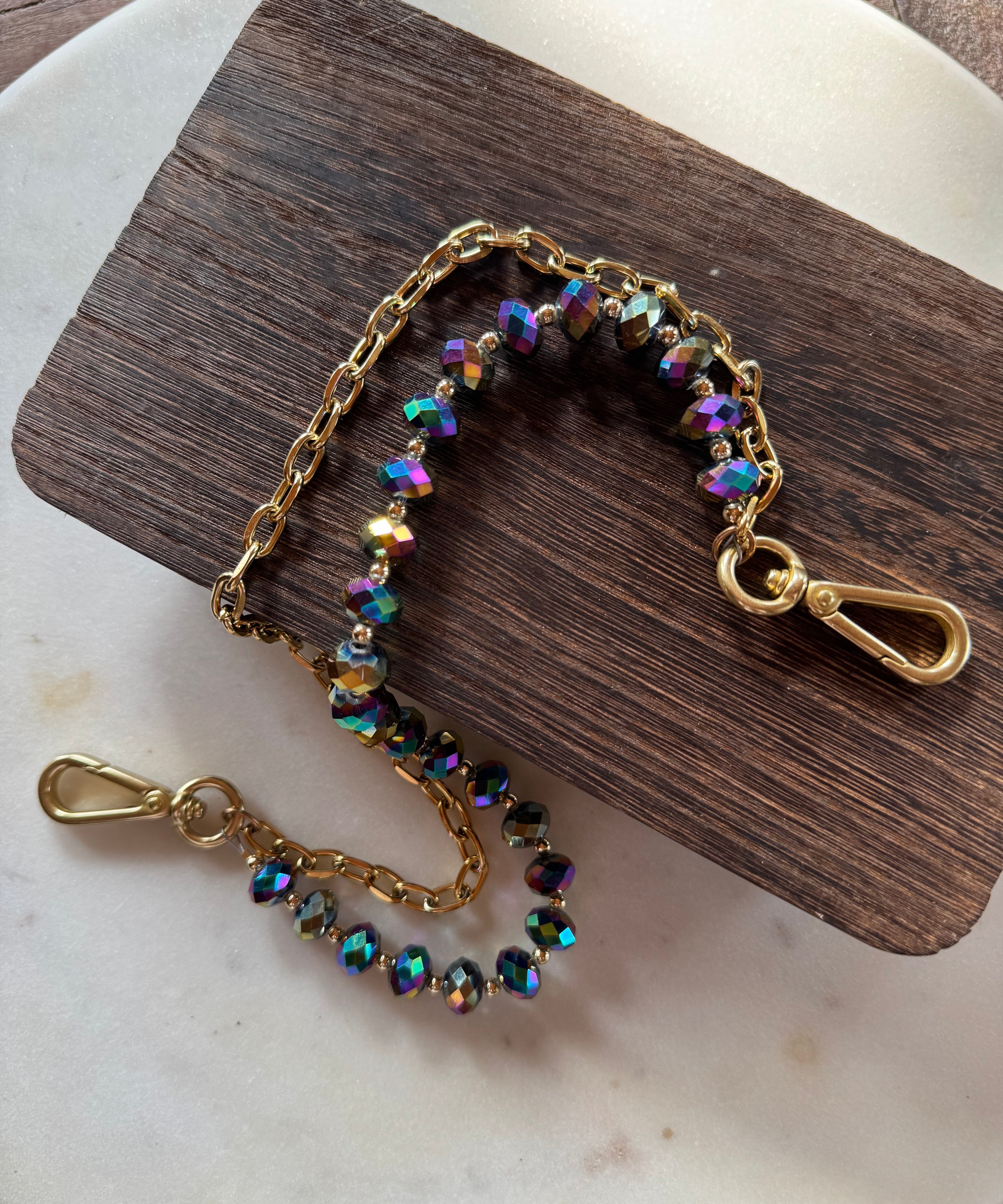 Jewelry with beads and chain on a wooden and marble surface