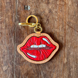 Keychain with red and gold design on a wooden surface