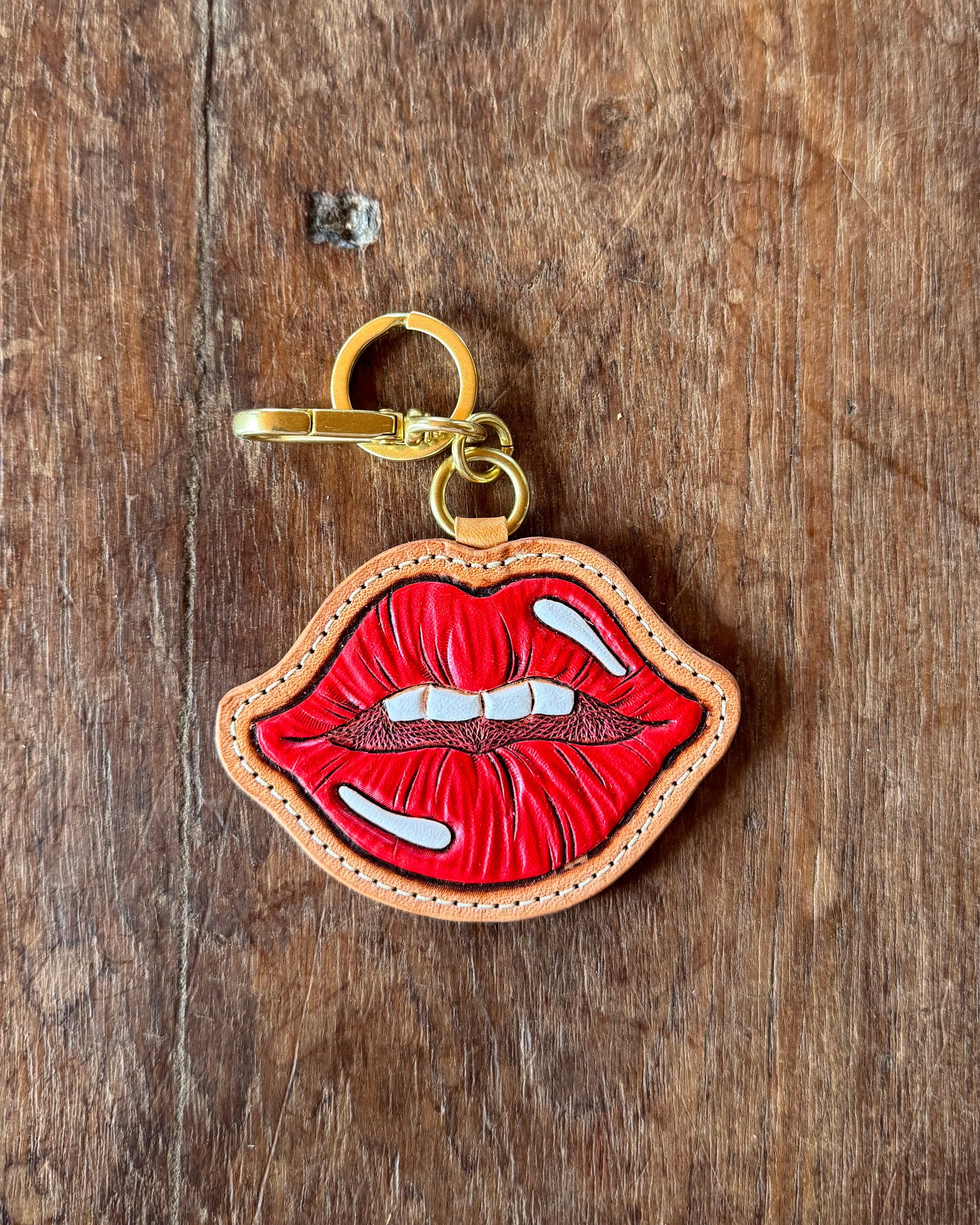 Keychain with red and gold design on a wooden surface