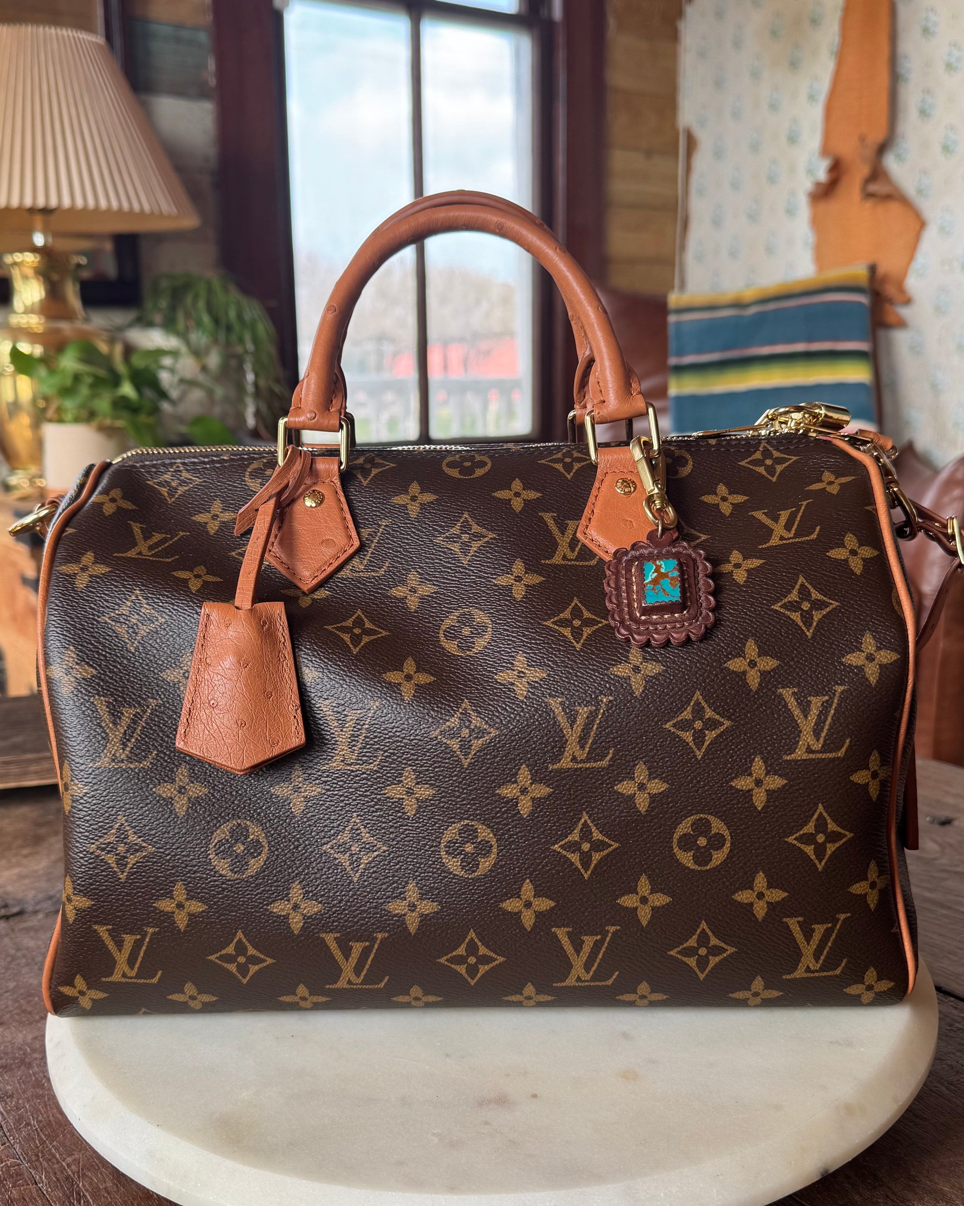 Designer handbag with monogram pattern on a wooden surface