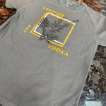 Gray t-shirt with a logo and text on a marble surface