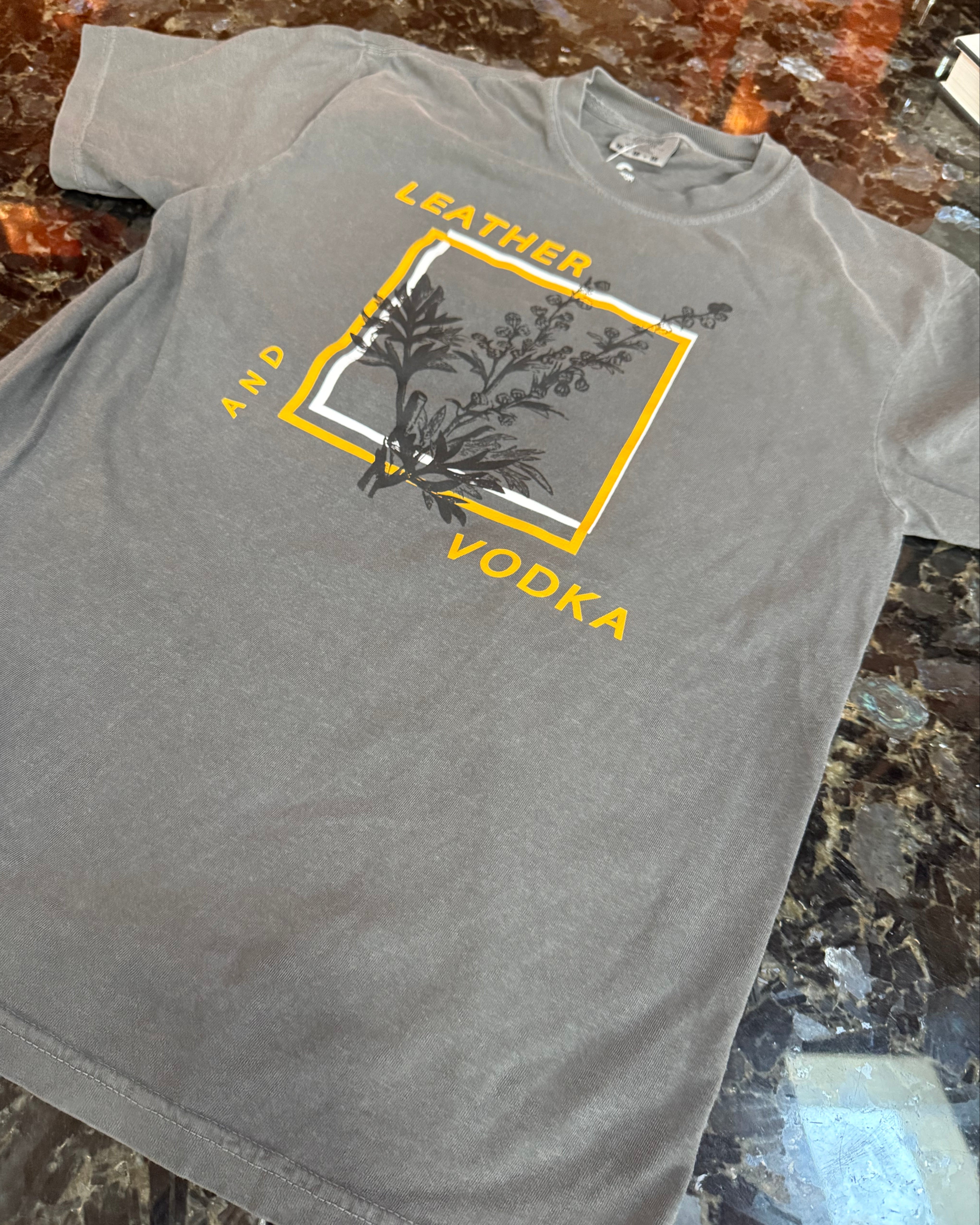 Gray t-shirt with a logo and text on a marble surface
