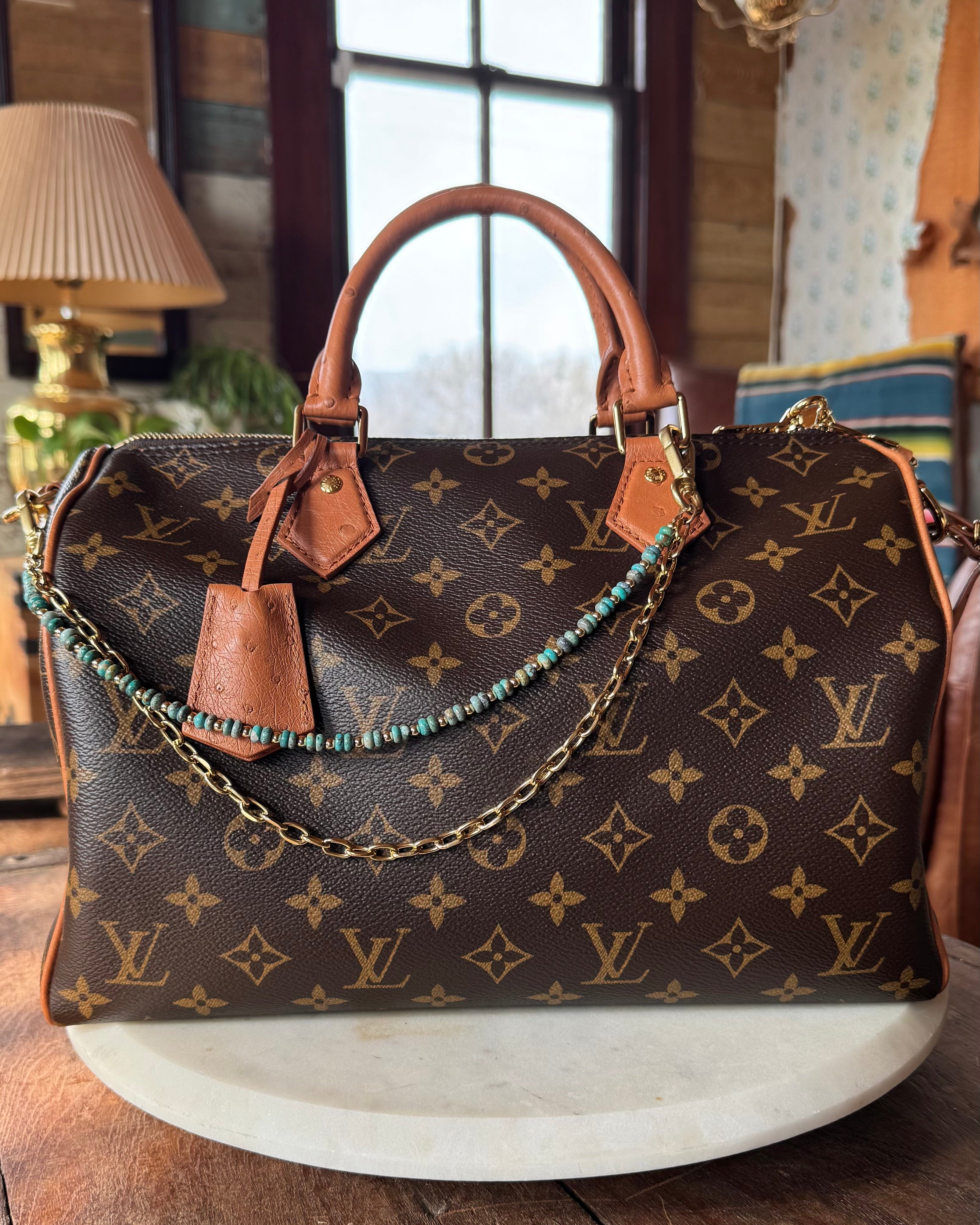 Designer handbag with monogram pattern on a wooden surface