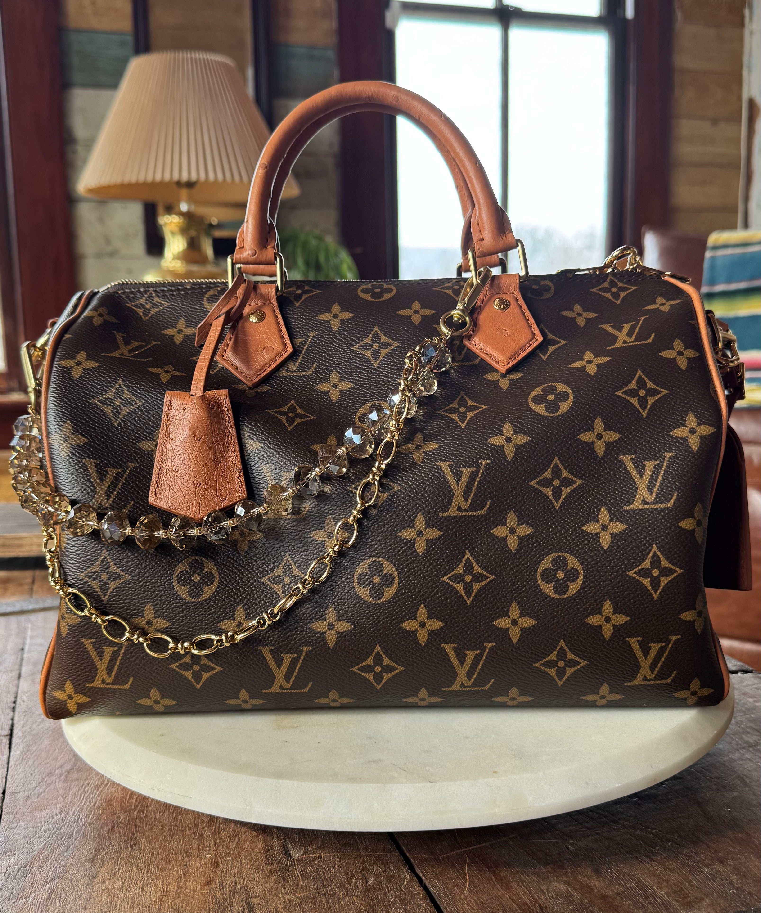 Designer handbag with monogram pattern on a wooden surface