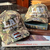 Two camouflage baseball caps with 'LAV' branding on a kitchen counter.