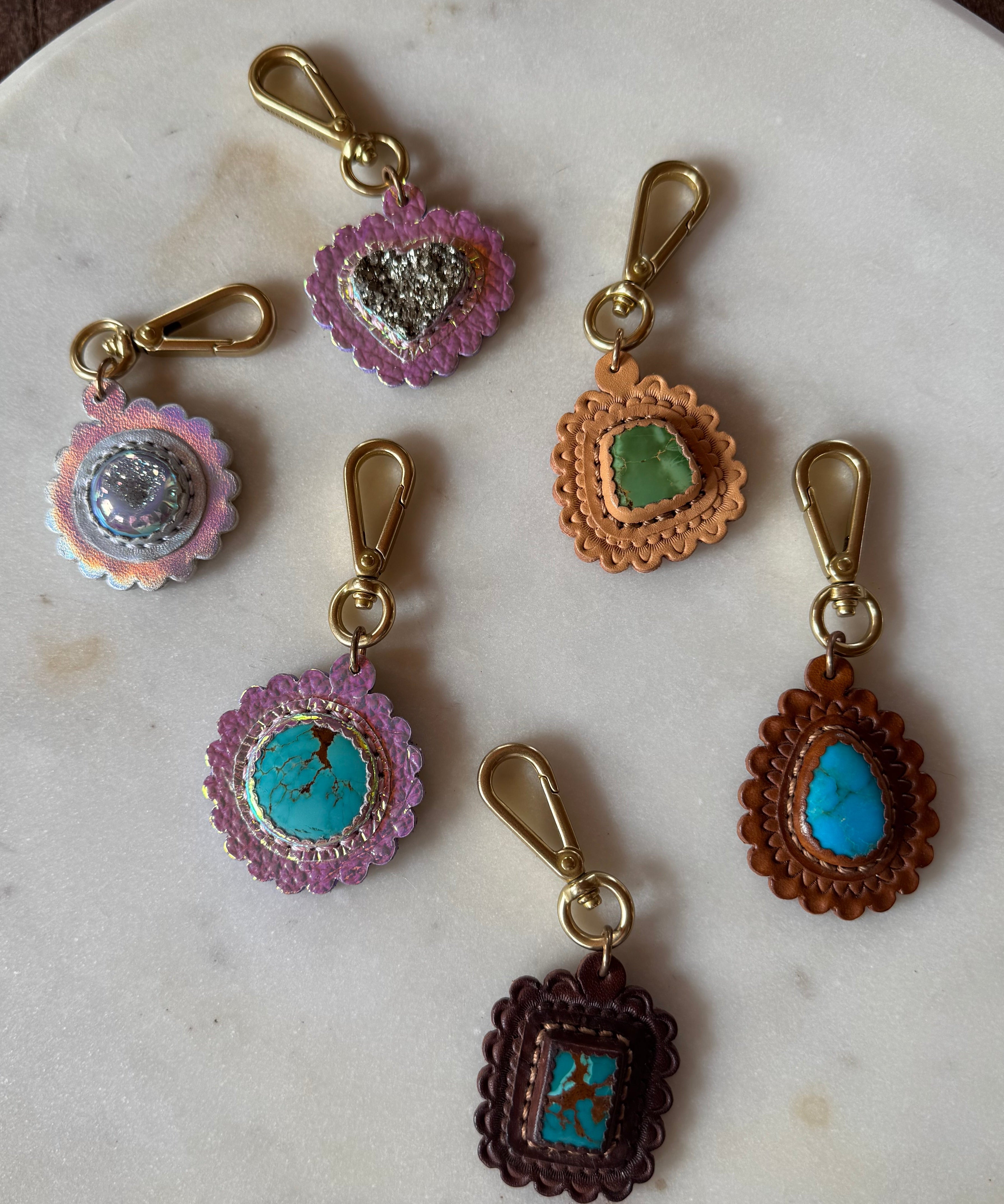 Decorative keychains with gemstone-like beads on a marble surface