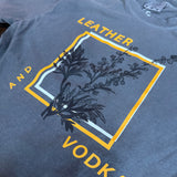 Gray tank top with 'Leather and Vodka' graphic design on a textured surface