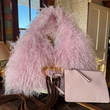 Pink Gucci Softbit Shearling handbag, with matching pink wallet, with a gold clasp on a wooden surface with Leather finge. Leather and Vodka, LAV