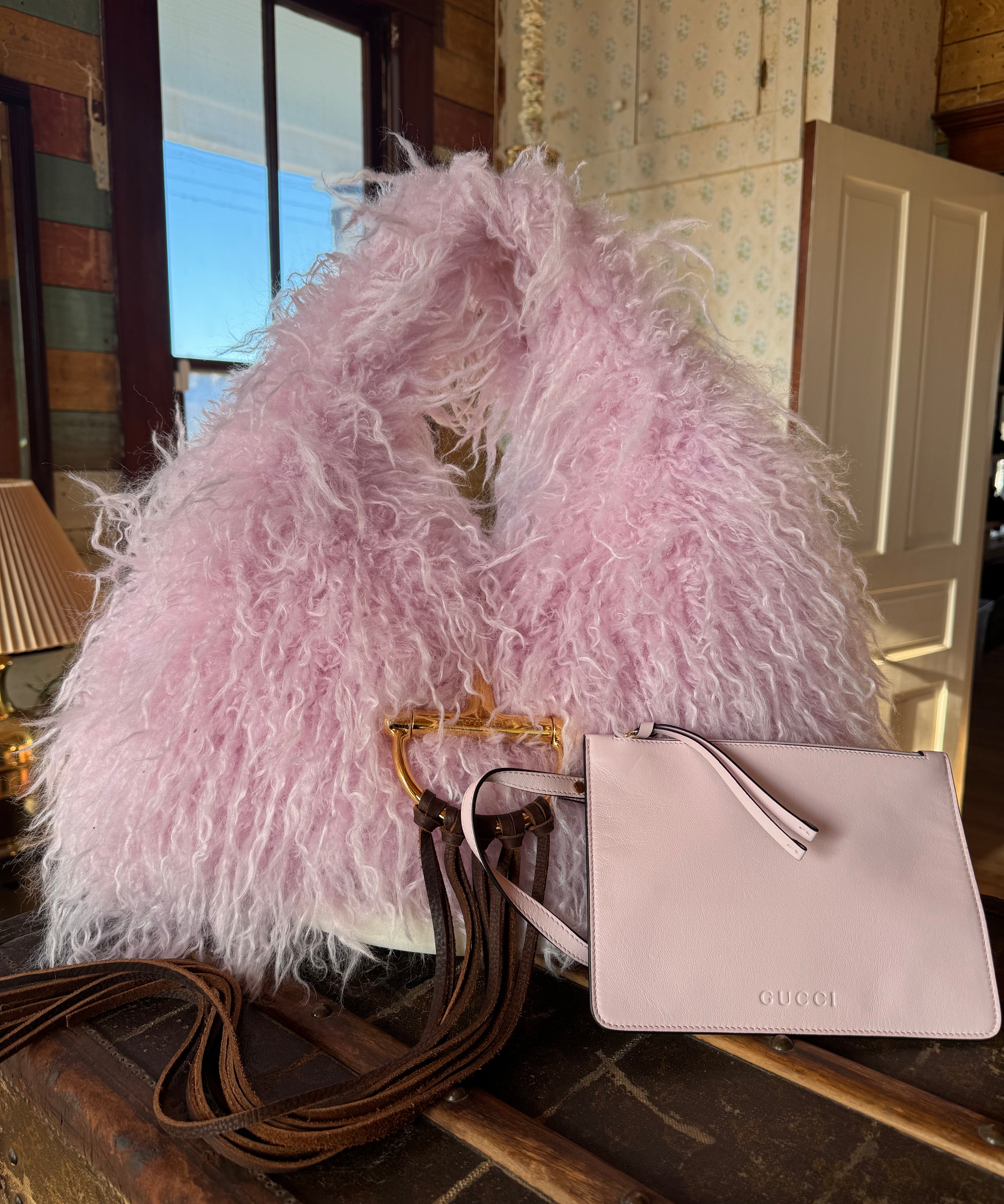 Pink Gucci Softbit Shearling handbag, with matching pink wallet, with a gold clasp on a wooden surface with Leather finge. Leather and Vodka, LAV