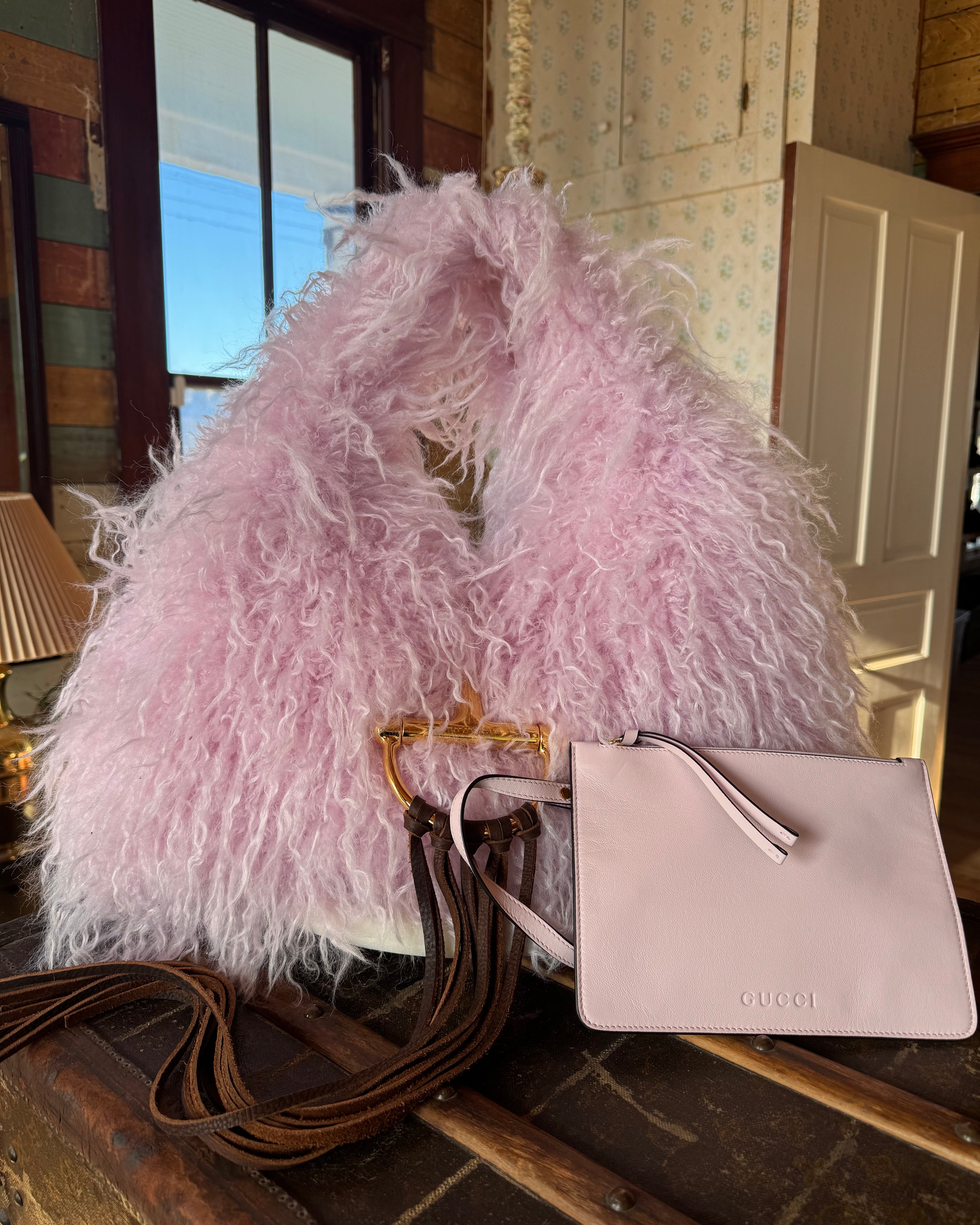 Pink Gucci Softbit Shearling handbag, with matching pink wallet, with a gold clasp on a wooden surface with Leather finge. Leather and Vodka, LAV