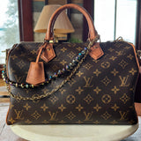 Designer handbag with monogram pattern on a wooden surface