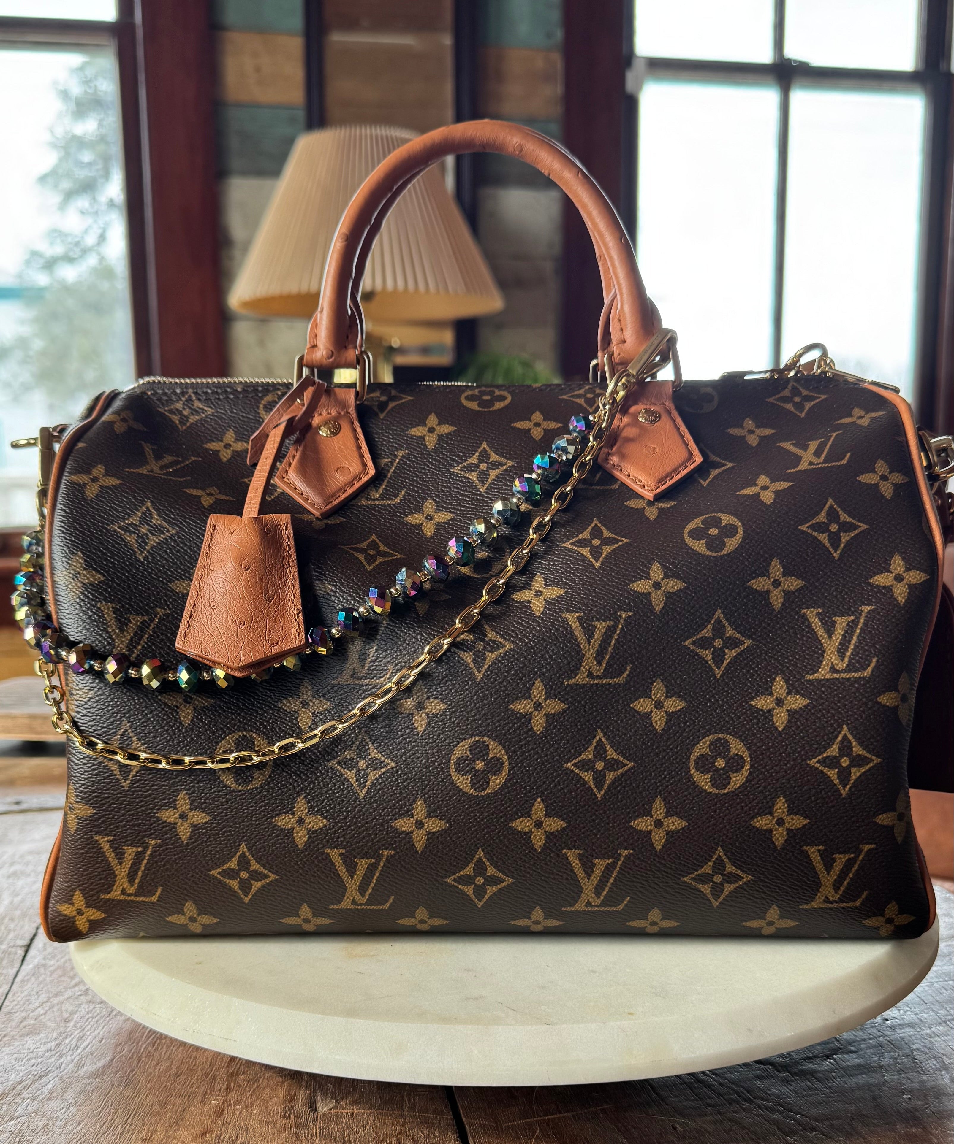 Designer handbag with monogram pattern on a wooden surface