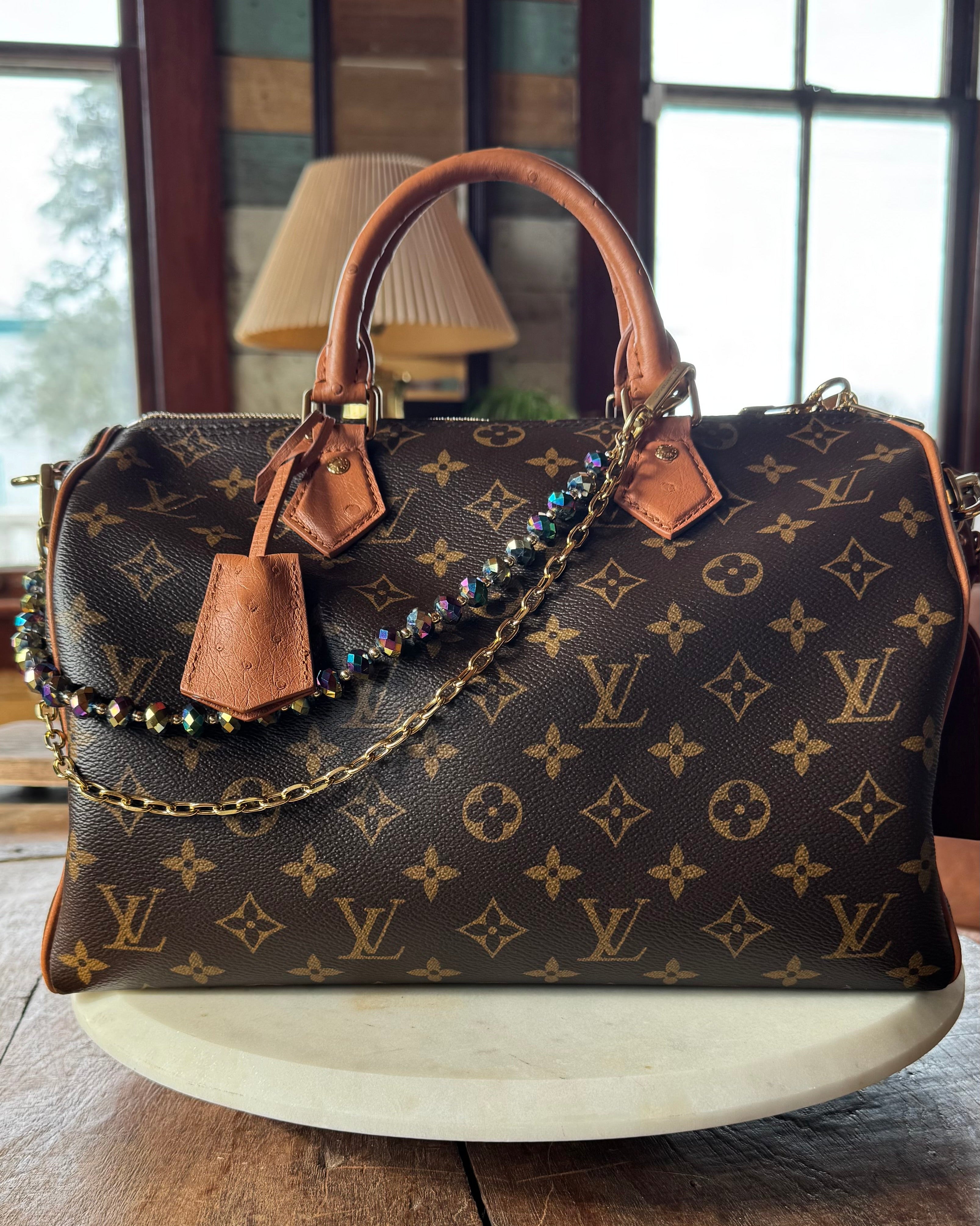 Designer handbag with monogram pattern on a wooden surface