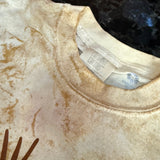 Close-up of a beige garment with a brand label and logo.