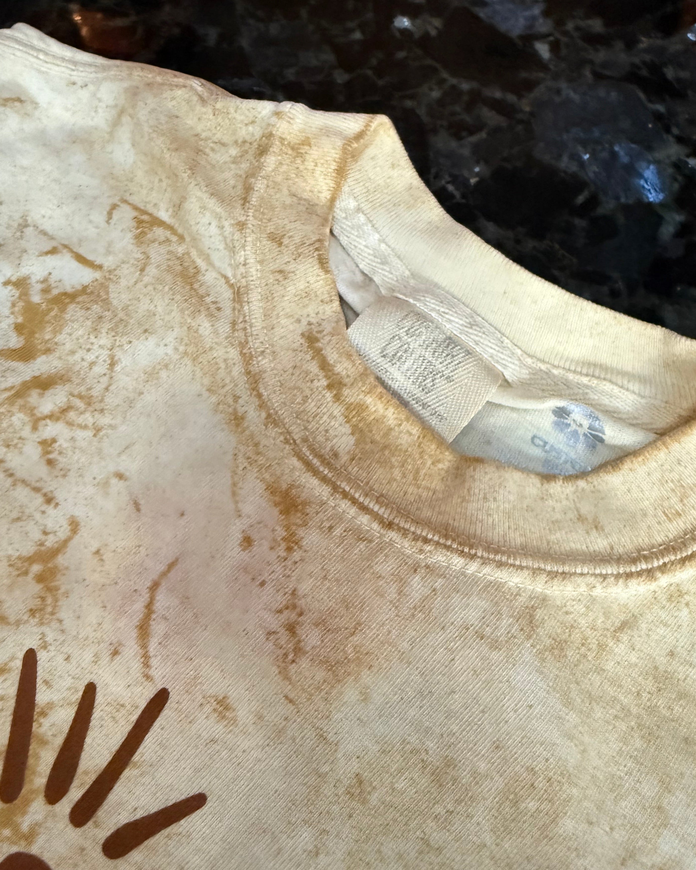 Close-up of a beige garment with a brand label and logo.