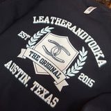 Black sweatshirt with white text and logo on a textured surface