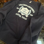 Black hoodie with white text and logo on a marble surface