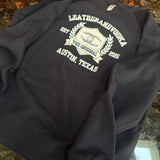 Black hoodie with white text and logo on a marble surface