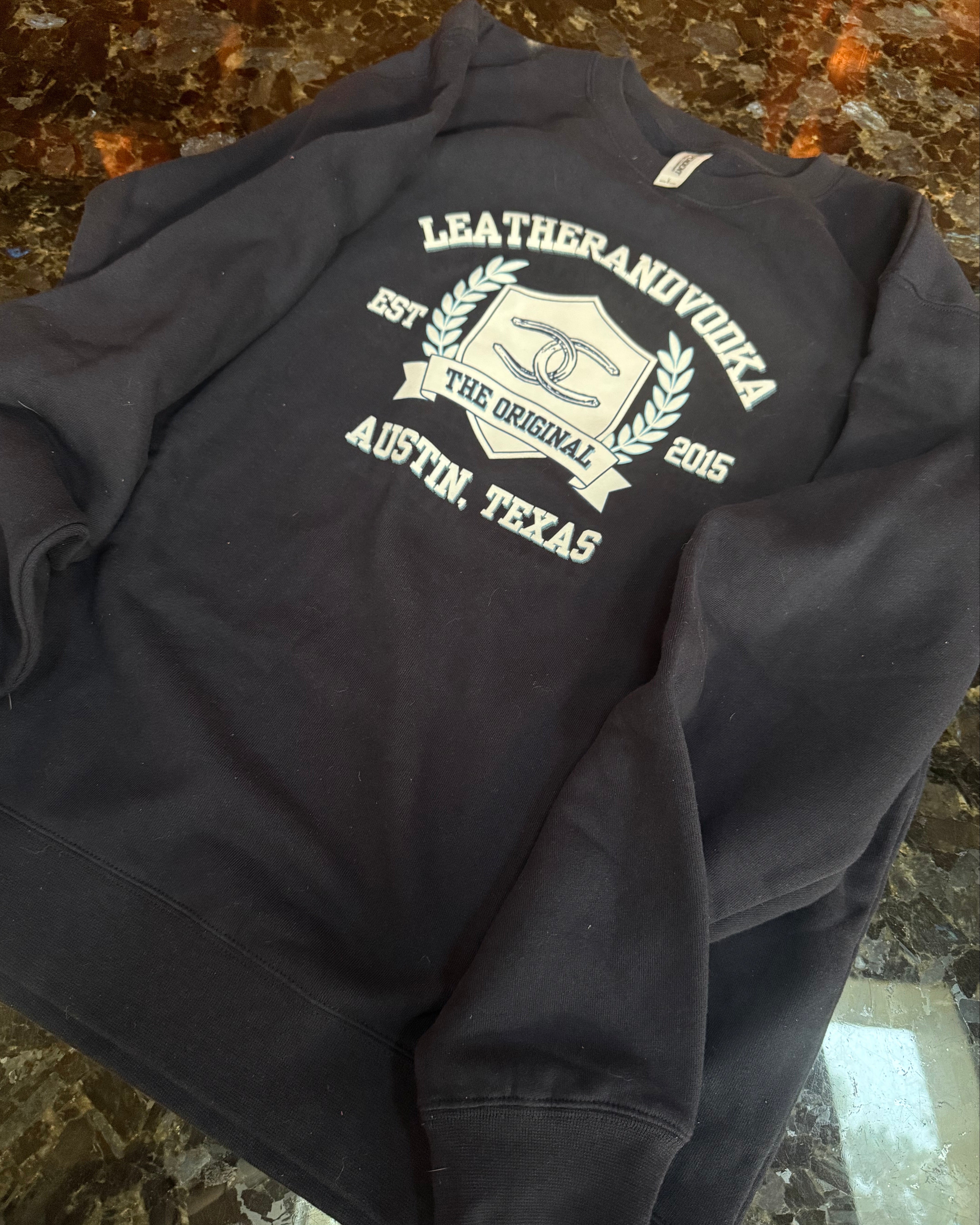 Black hoodie with white text and logo on a marble surface