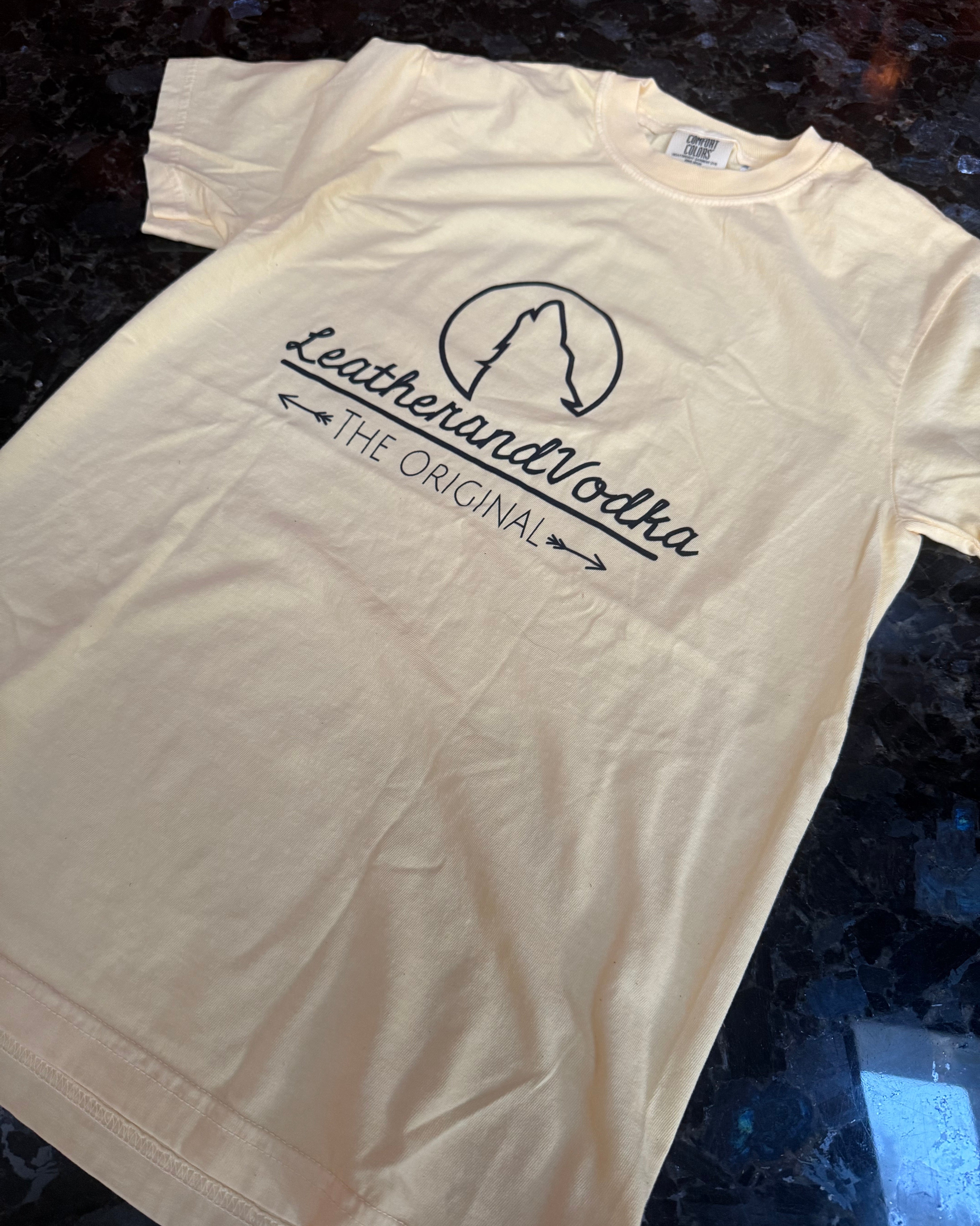 White t-shirt with a logo and text on a dark surface