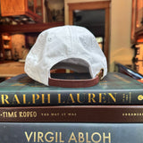 white baseball cap sitting on books in kitchen
