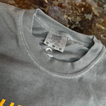 Gray t-shirt with a brand tag on a marble surface
