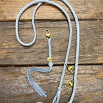 Powder blue leather bag strap with gold clasps on a wooden surface