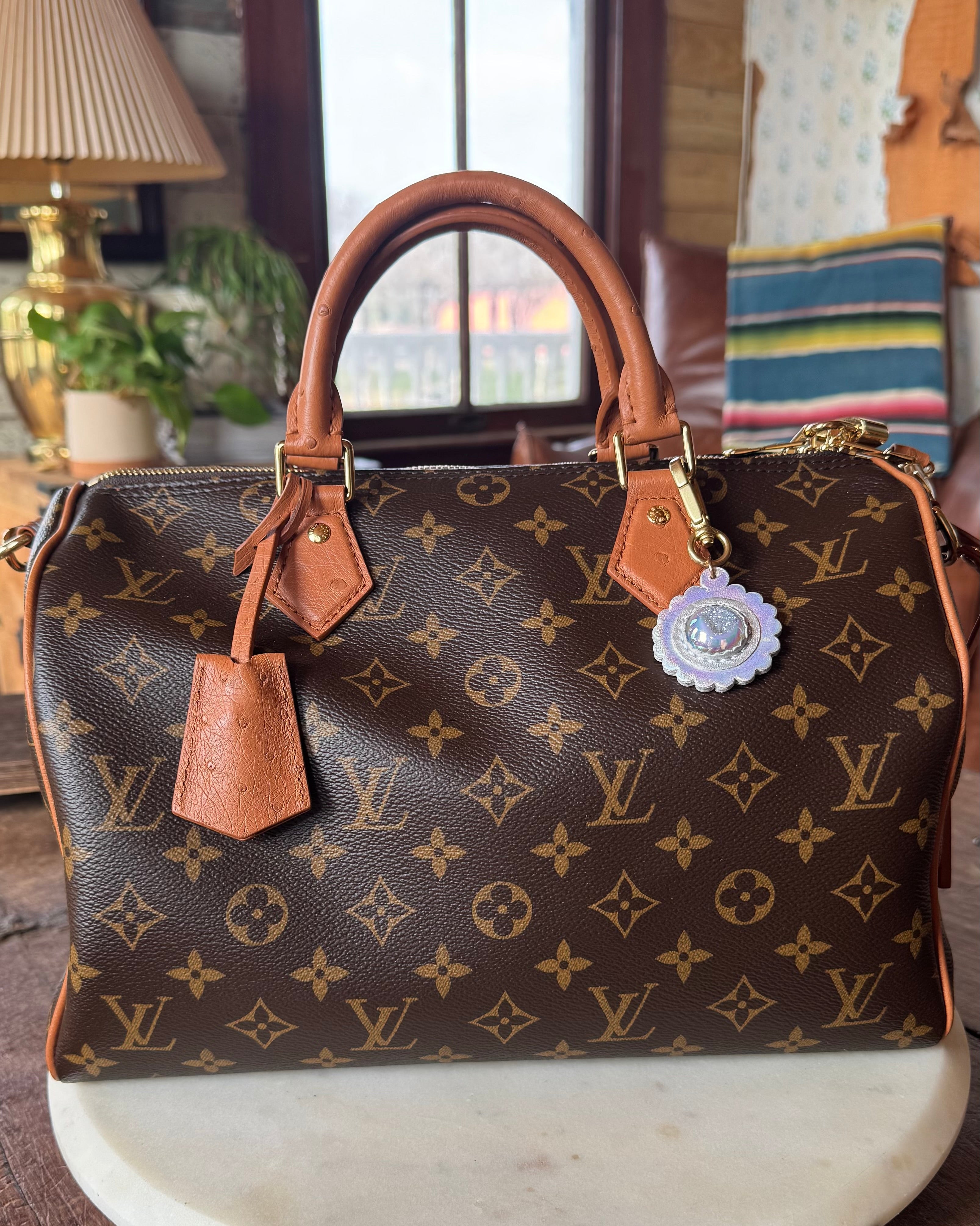 Designer handbag with monogram pattern on a marble surface