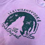 Purple shirt with a black graphic and text on a blurred background