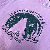 Purple shirt with a black graphic and text on a blurred background