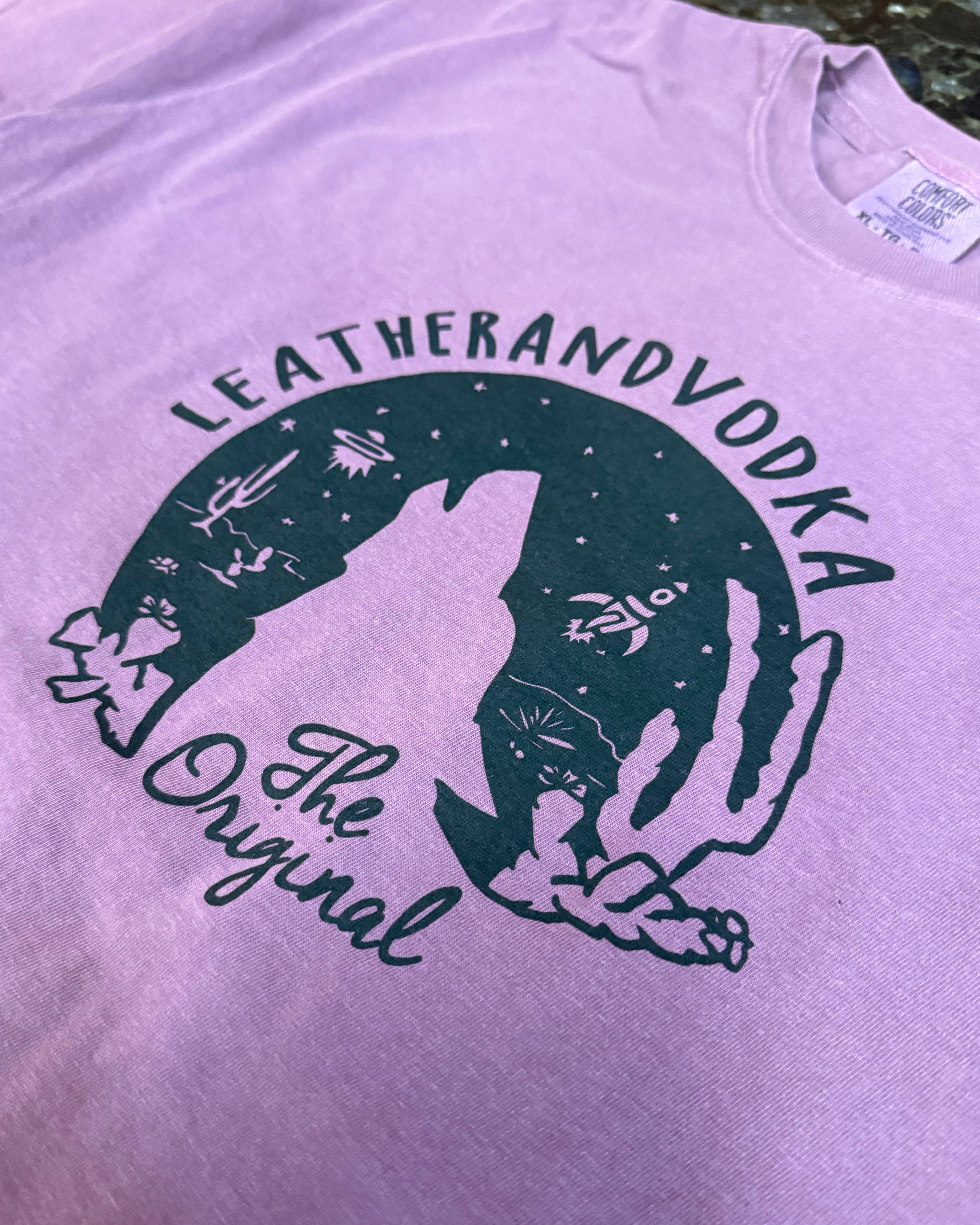 Purple shirt with a black graphic and text on a blurred background