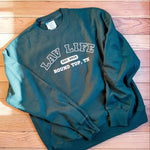 Green sweatshirt with LAV Life, Round Top, Texas text on a wooden surface