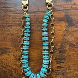 Turquoise beaded chain with gold clasp on a wooden surface, J Forks & Leather and Vodka
