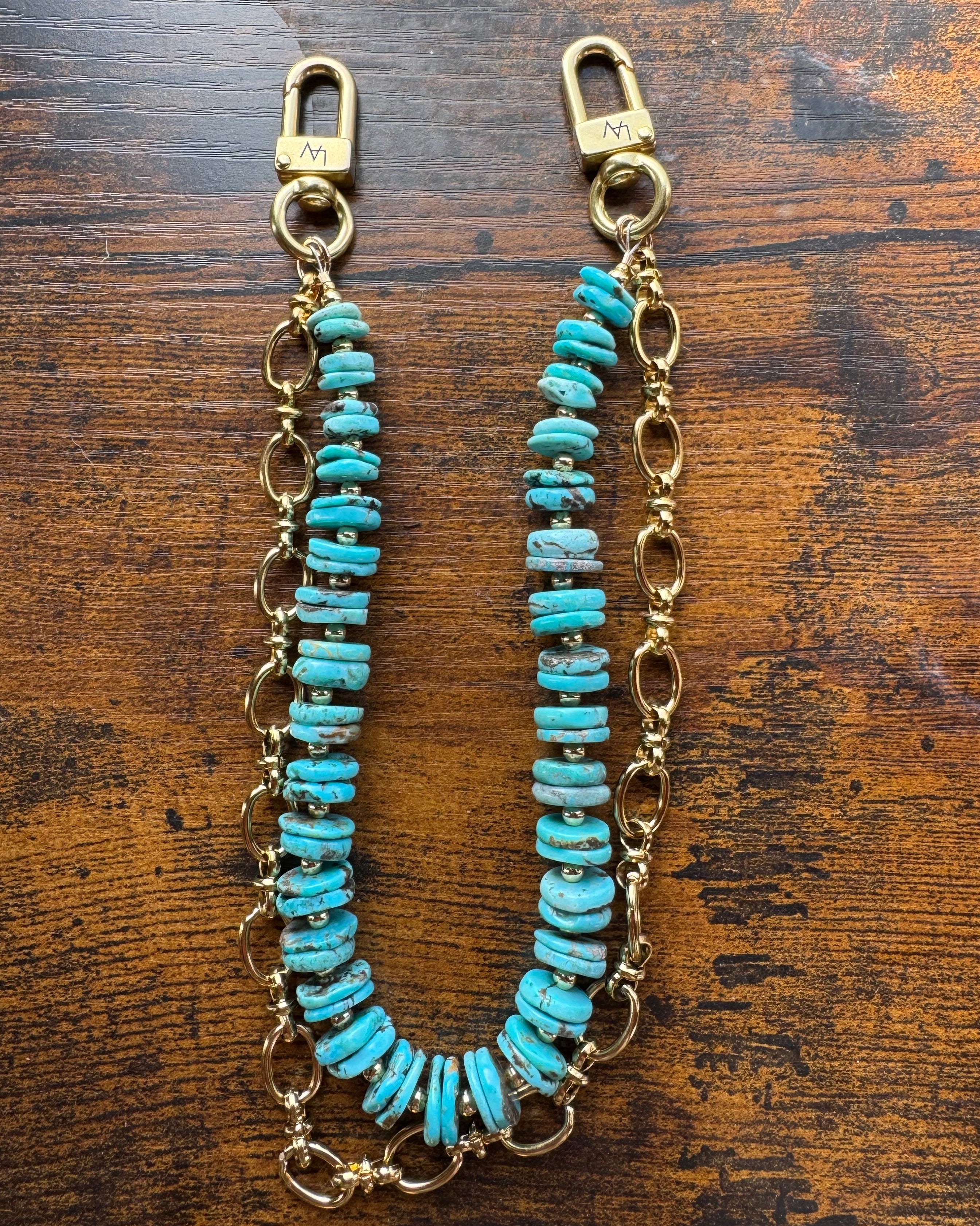 Turquoise beaded chain with gold clasp on a wooden surface, J Forks & Leather and Vodka