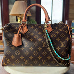 Designer handbag with monogram pattern on a wooden surface