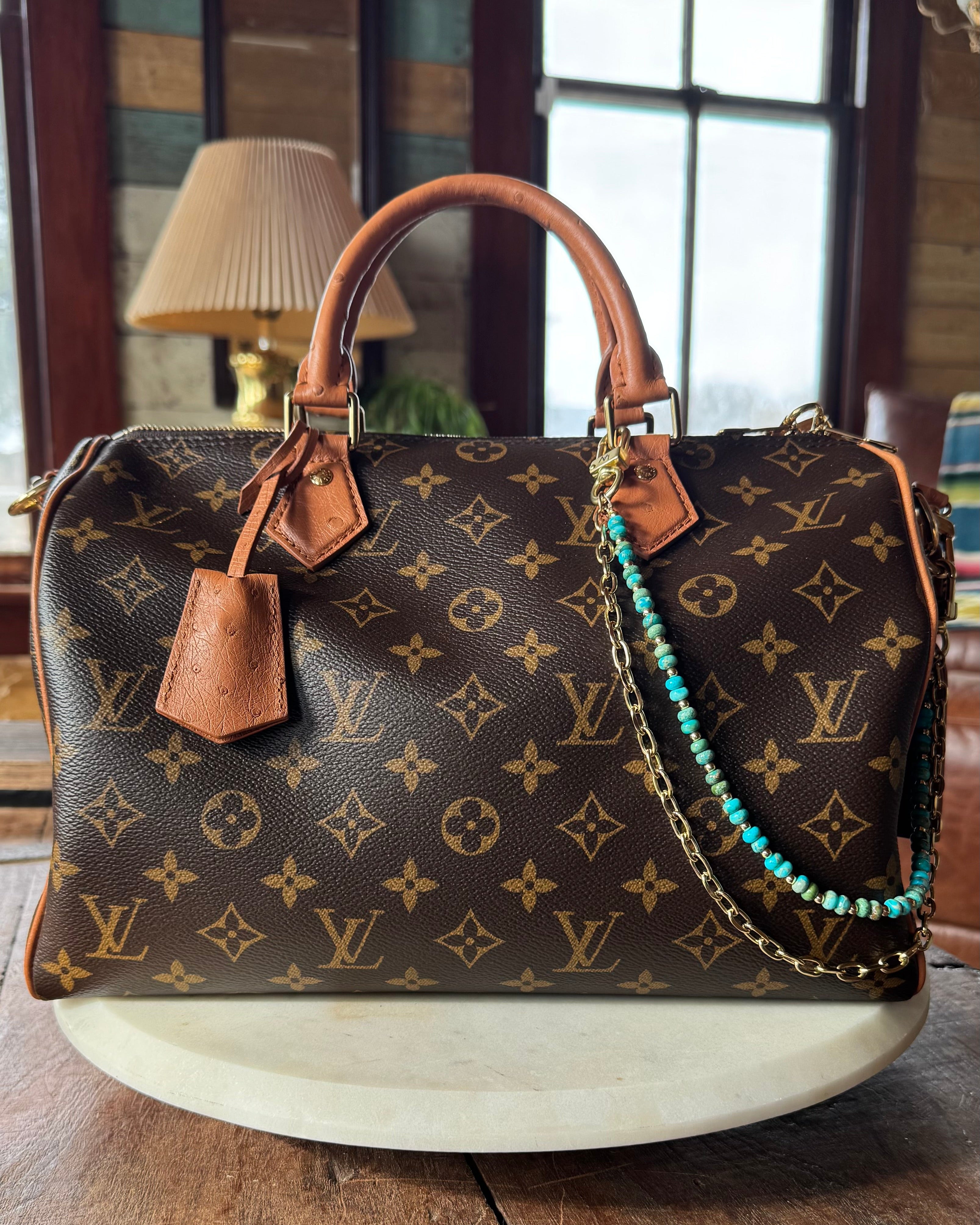 Designer handbag with monogram pattern on a wooden surface