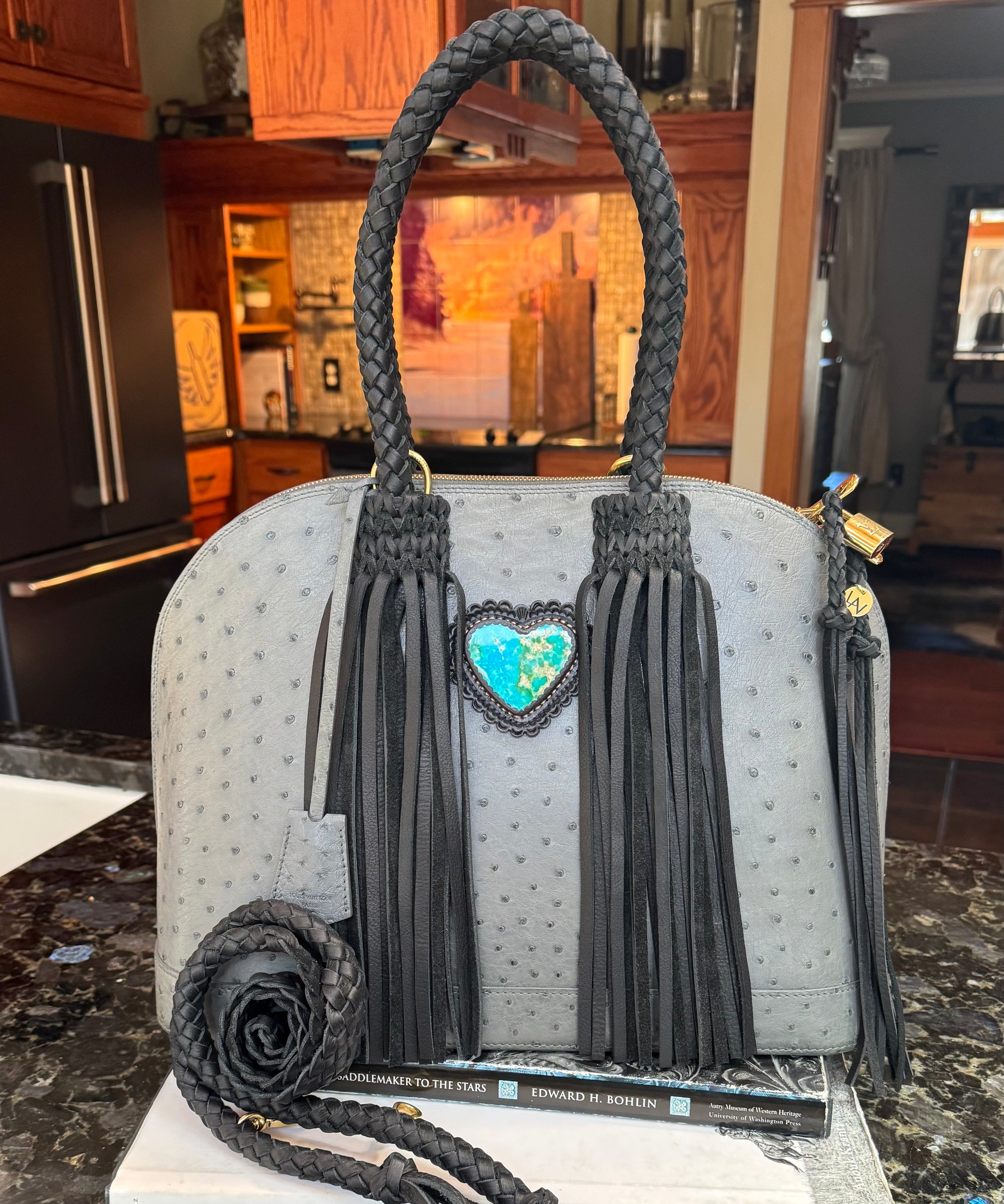 Handbag with tassels on a marble surface in a kitchen setting