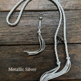 Metallic SIlver Bag Strap, made with braided leather with matching snap on key chain, laying on wooden table. 