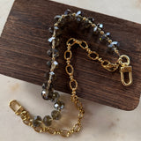 Gold chain with embedded stones on a wooden block
