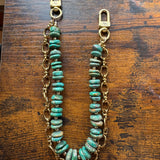 Turquoise beaded chain on a wooden surface, J Forks & Leather and Vodka