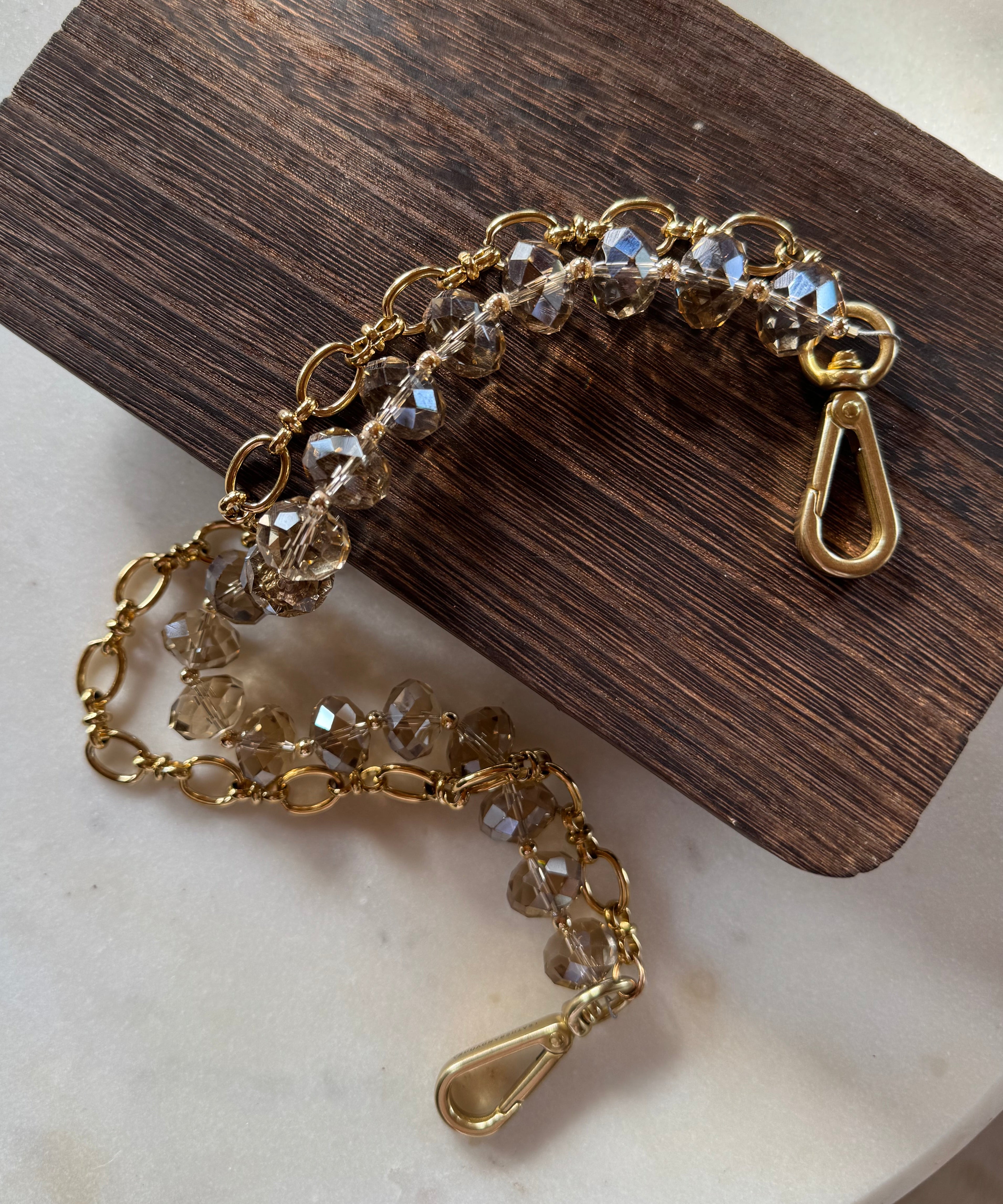 Gold chain handbag chain with clear stones on a wooden block