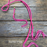 barbie pink colored leather bag strap with gold clasps on a wooden surface