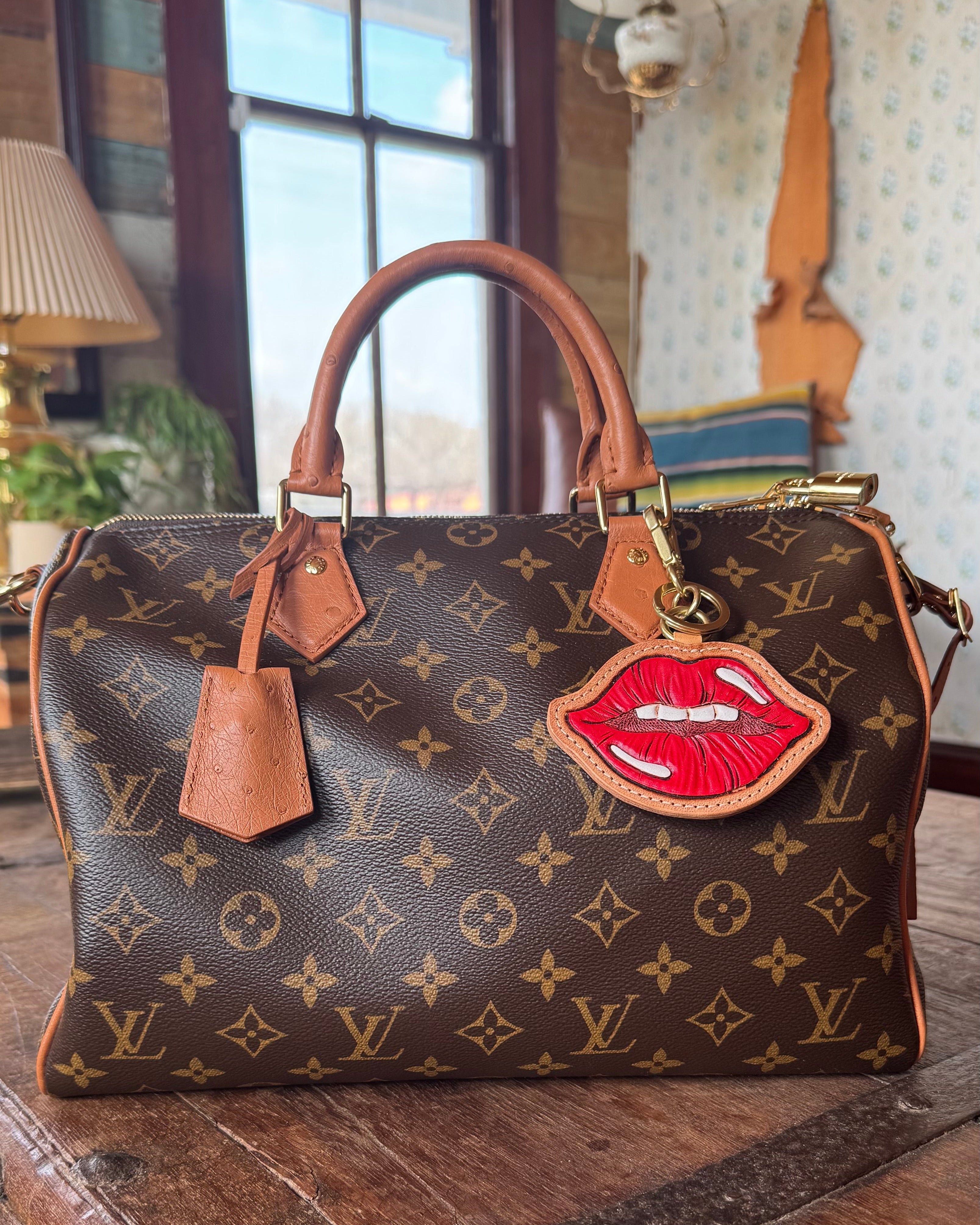 Designer handbag with a unique lip-shaped tag on a wooden surface