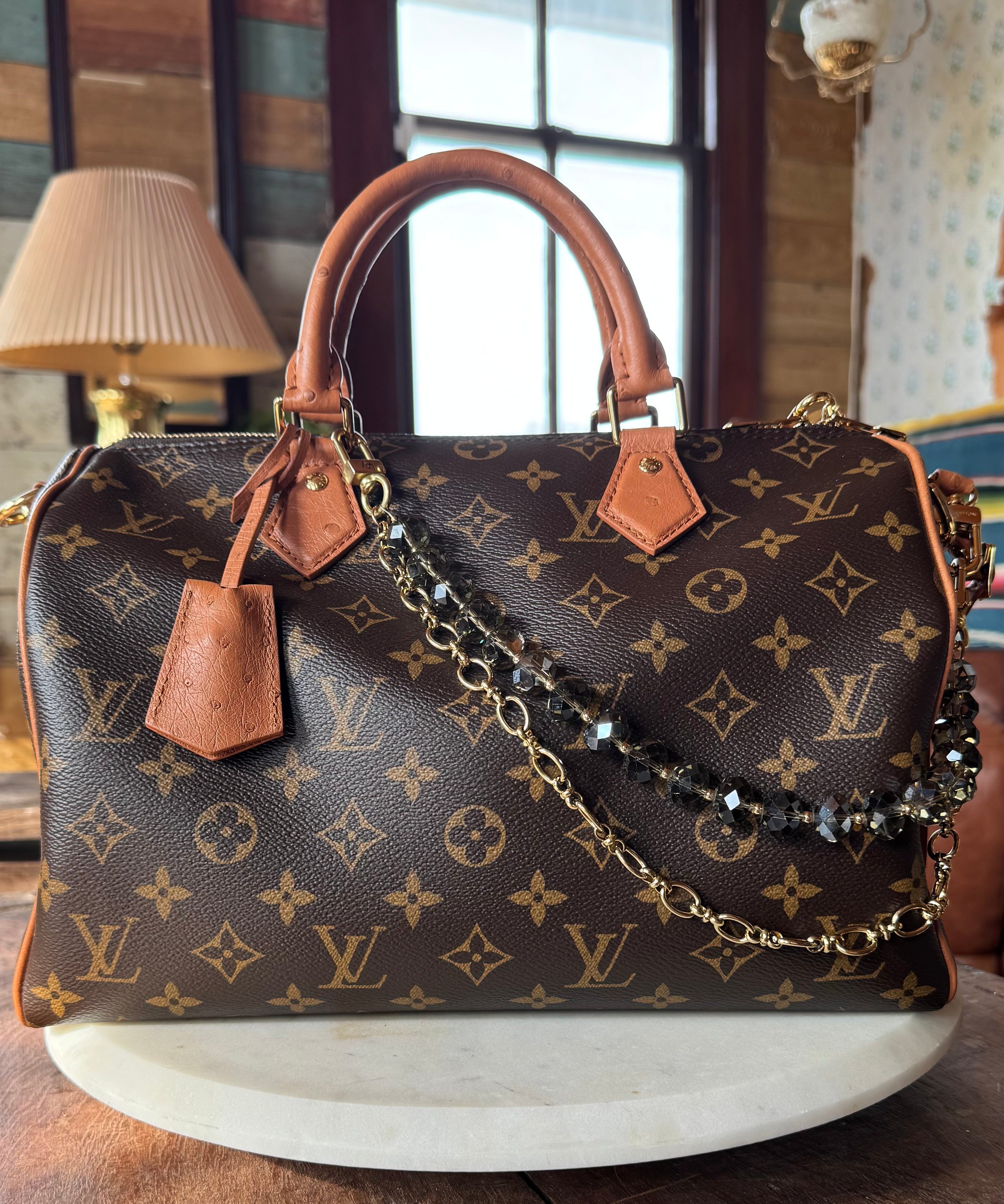 Designer handbag with monogram pattern on a wooden surface