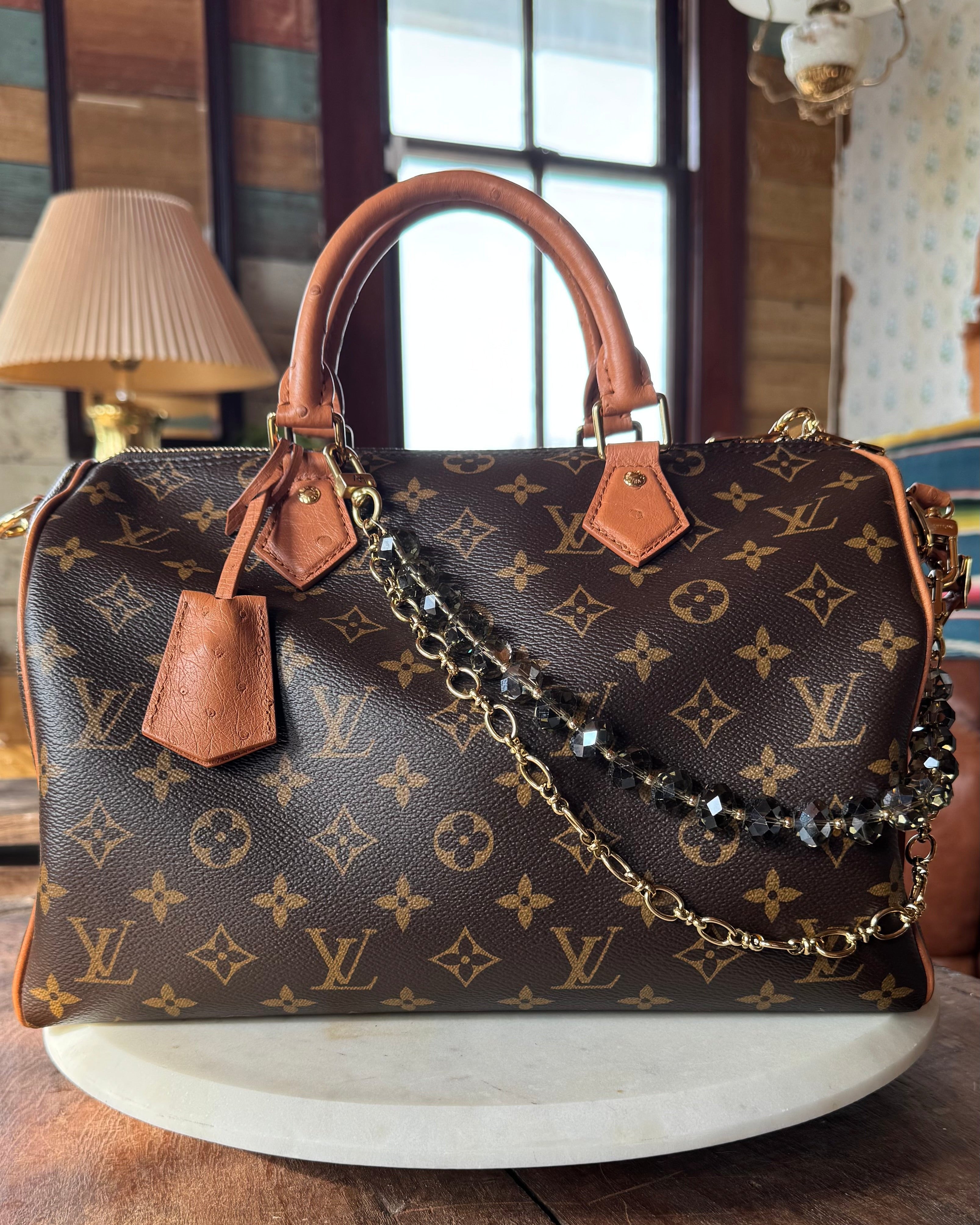 Designer handbag with monogram pattern on a wooden surface