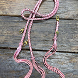 Metallic Pink Bag Strap, made with braided leather with matching snap on key chain, laying on wooden table. 