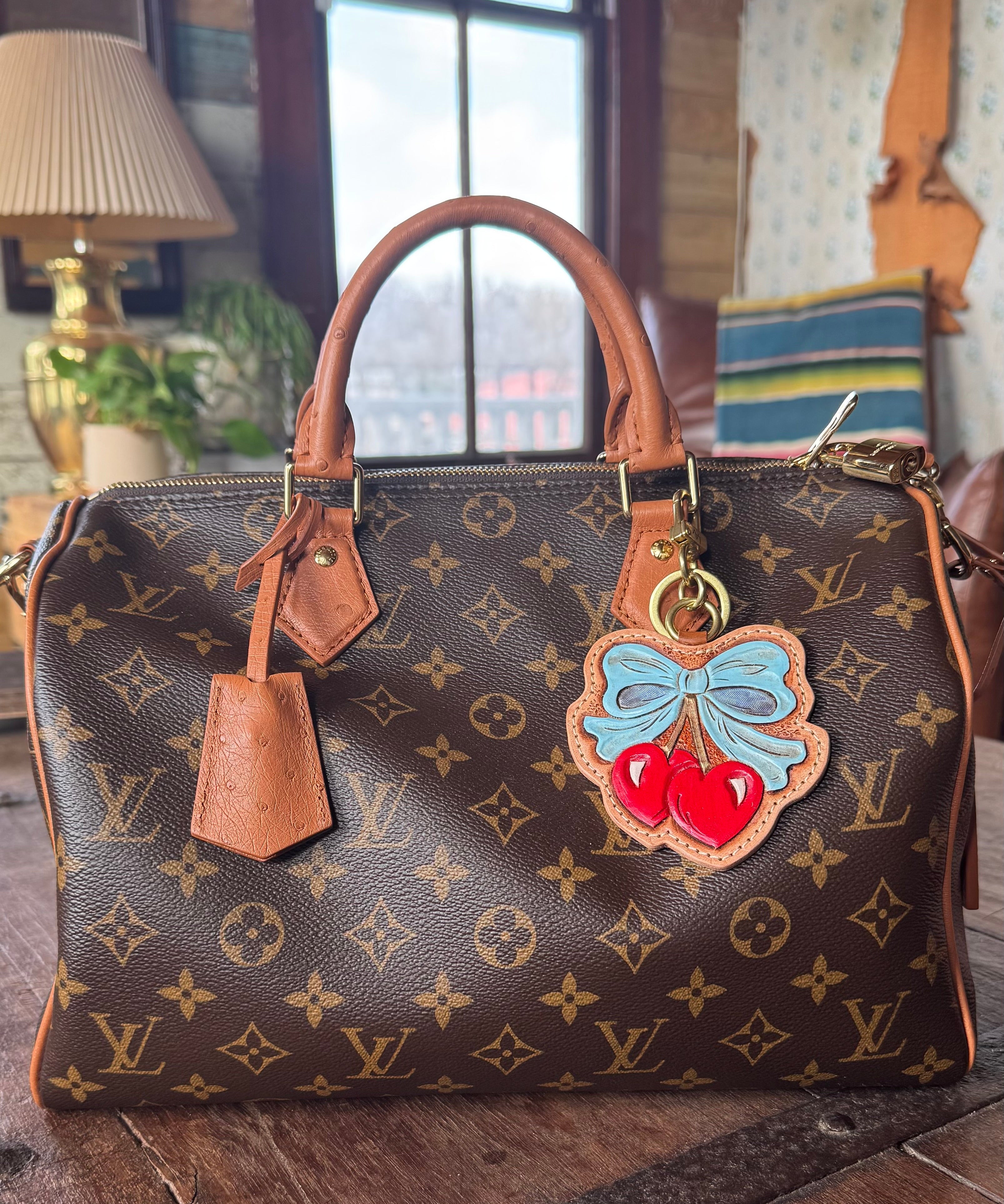 Designer handbag with decorative charm on a wooden surface