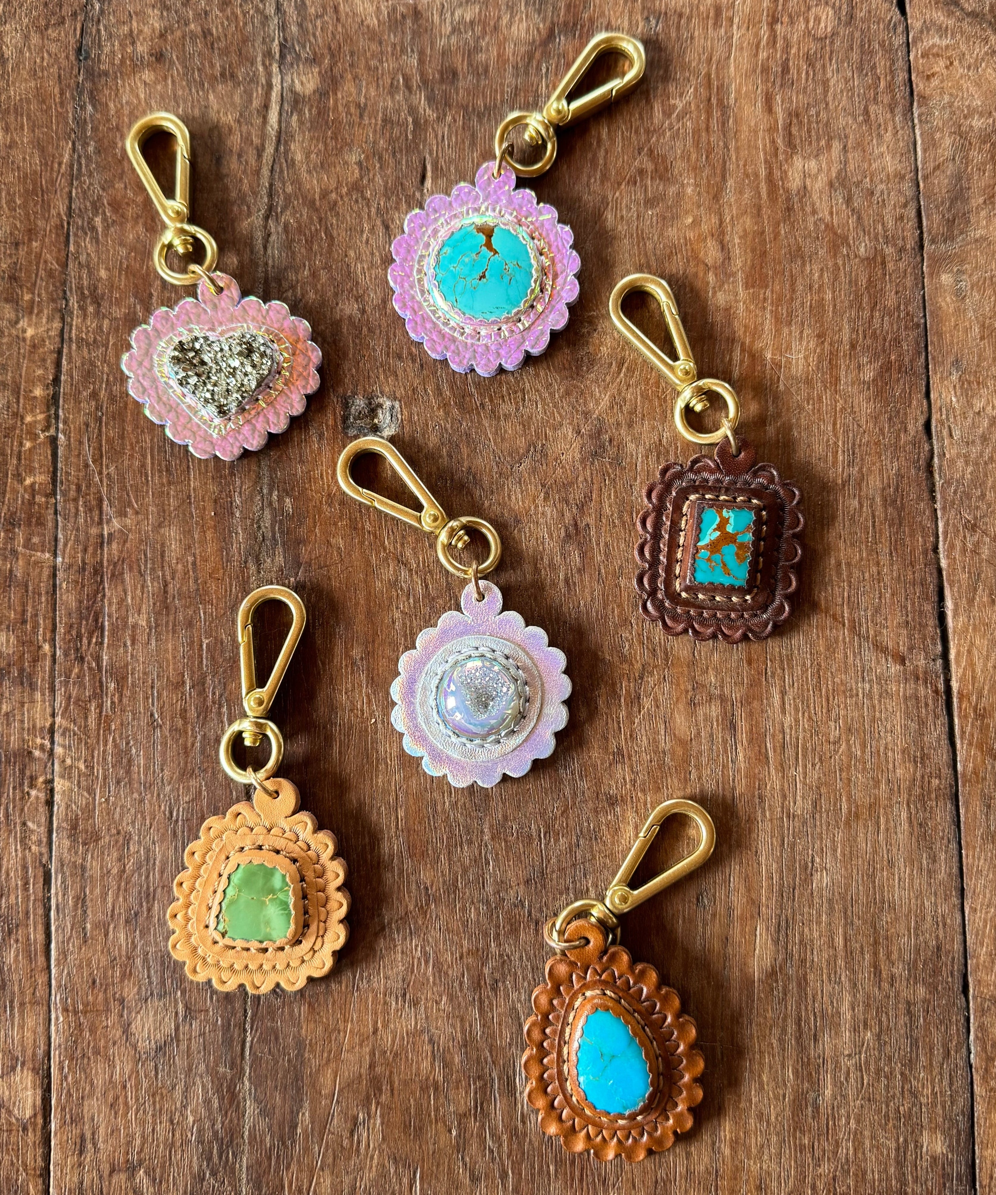 Decorative keychains with gemstone-like centers on a wooden surface