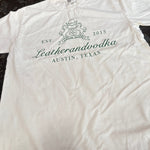 White shirt with words leatherandvodka on a dark surface